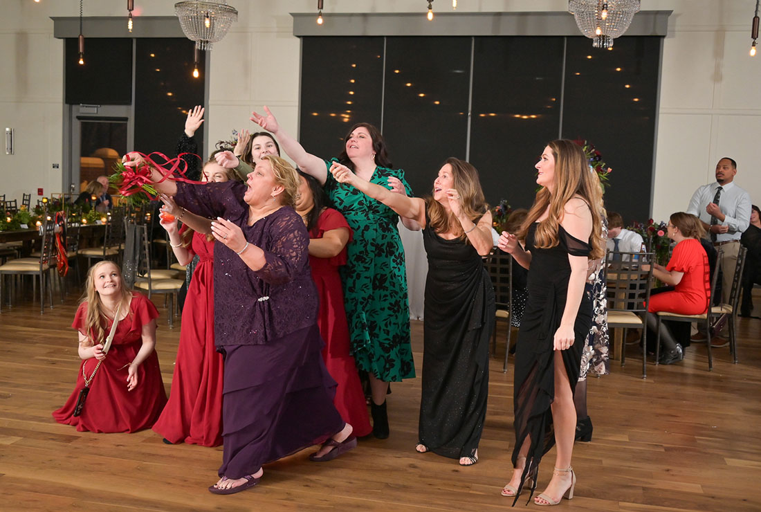 The groom's Mom leaps into the air to snag the bouquet at 2GatherMore, a wedding venue in Auburn Hills, Michigan.