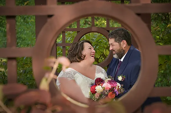 Bride in groom under the wedding ceremony trellis at Ann Arbor City Club in Ann Arbor, Michigan..