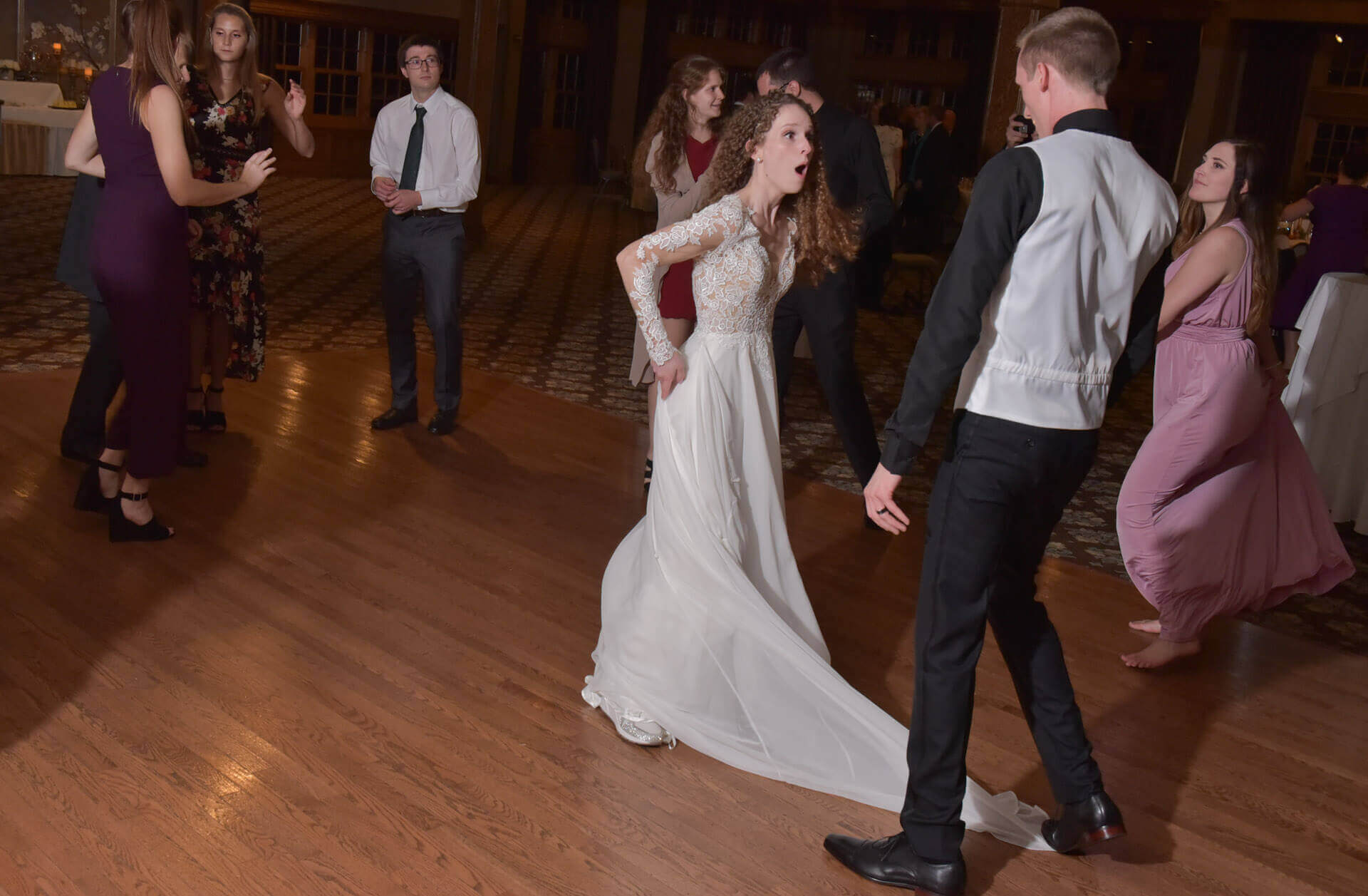 A bride turns around on the dance floor when her husband steps on the train of her dress at Addison Oaks, Michigan.
