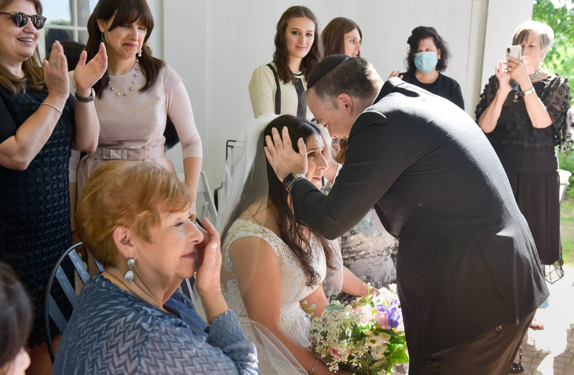 The bride receives a blessing from her brother during her orthodox Jewish wedding held during the pandemic at Waldenwoods Resort in Howell, Michigan.