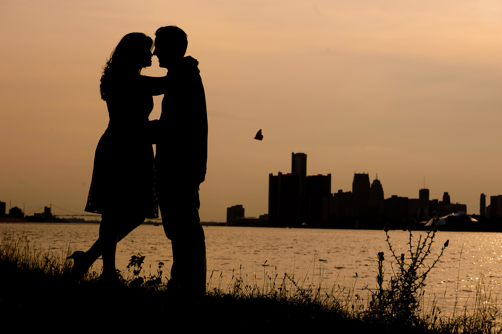 Detroit engagement photographer photographs of a fun little sunset moments like this butterfly going by during a Belle Isle engagement photography session in Detroit, Michigan area.