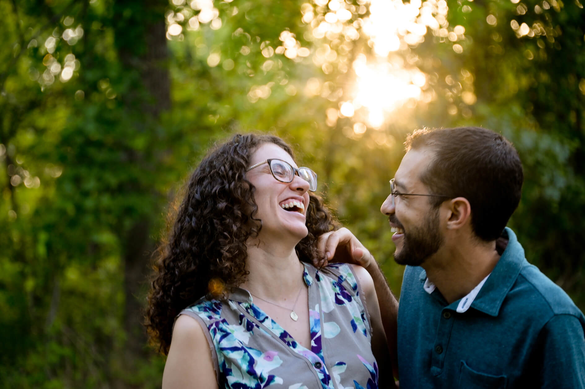 Clients in great afternoon light for engagement lifestyle sessions in metro Detroit, Michigan sharing a laugh.