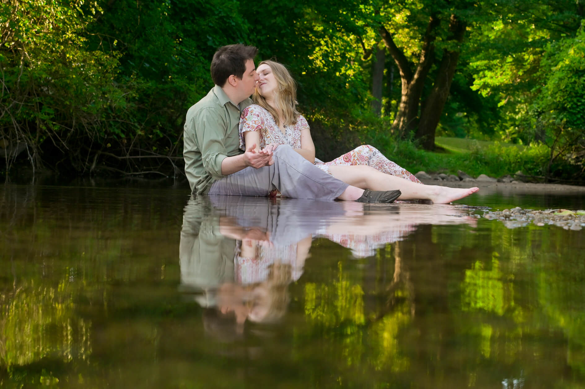 Couple favorite Detroit engagement photographer's engagement photos of a newly engaged couple snuggling in a river in a metro Detroit, Michigan area park.
