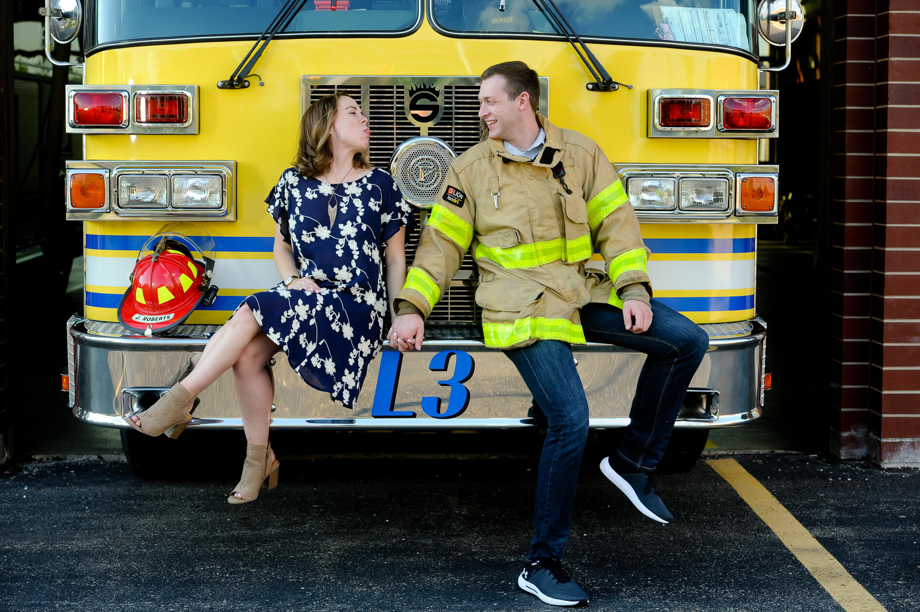 Silly and fun engagement picture of a couple on the groom to be's fire truck in Troy, Michigan.