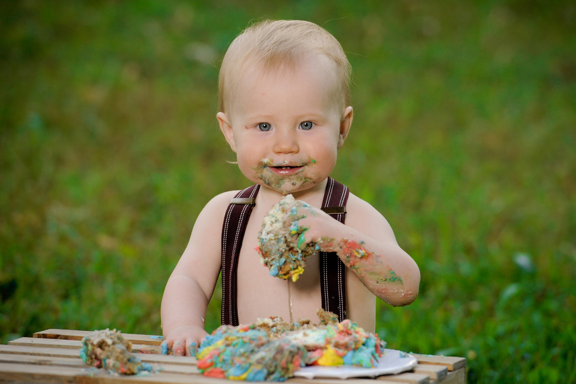 Best Detroit family photographer's fun and candid photos of a little boy turning one and demolishing his birthday cake during this family lifestyle session in metro Detroit, Michigan.