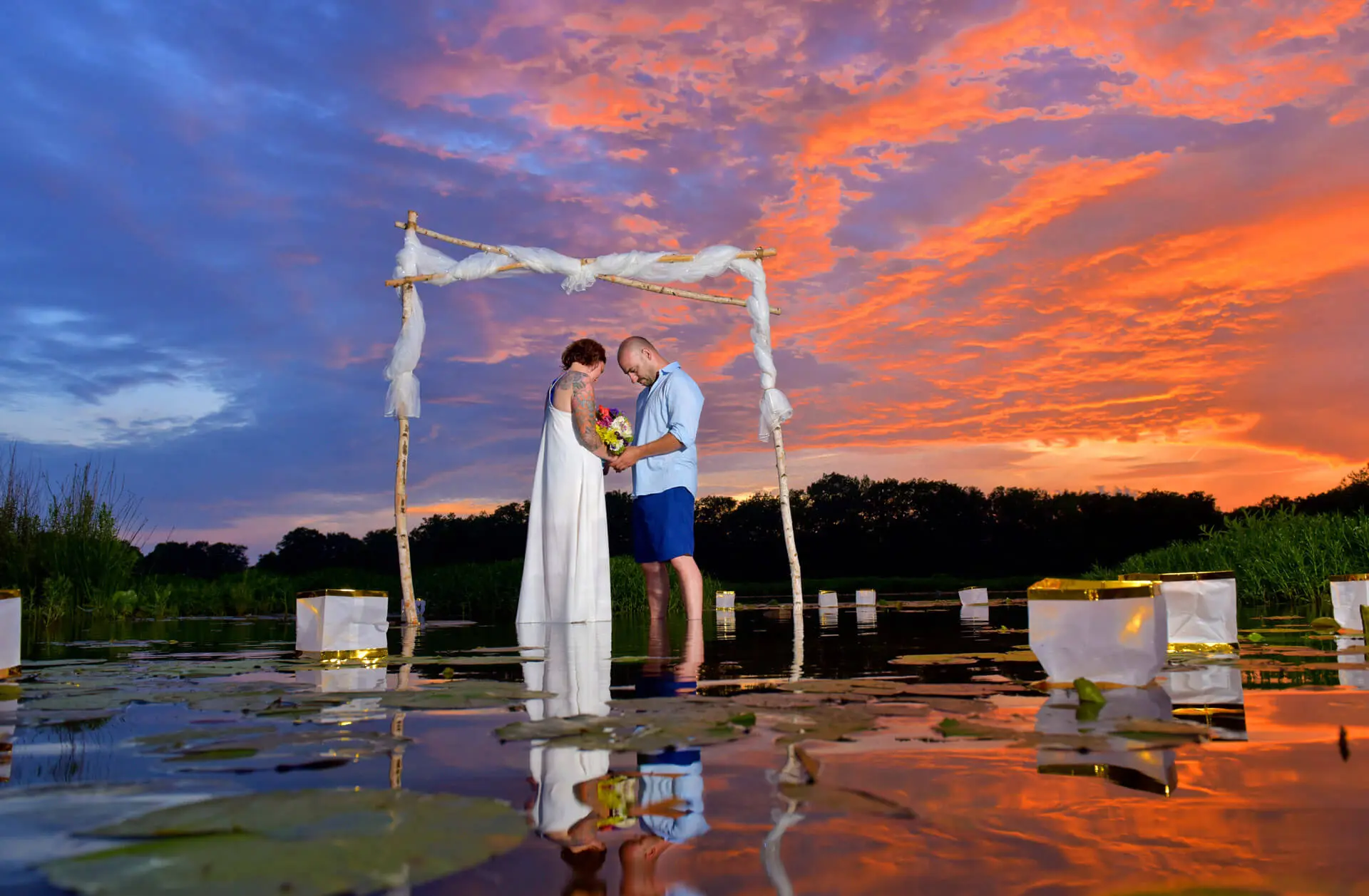 Fantastic sunset wedding on a sand bank in the middle of a river in Jackson, Michigan makes for a gorgeous, once in a lifetime wedding photo.