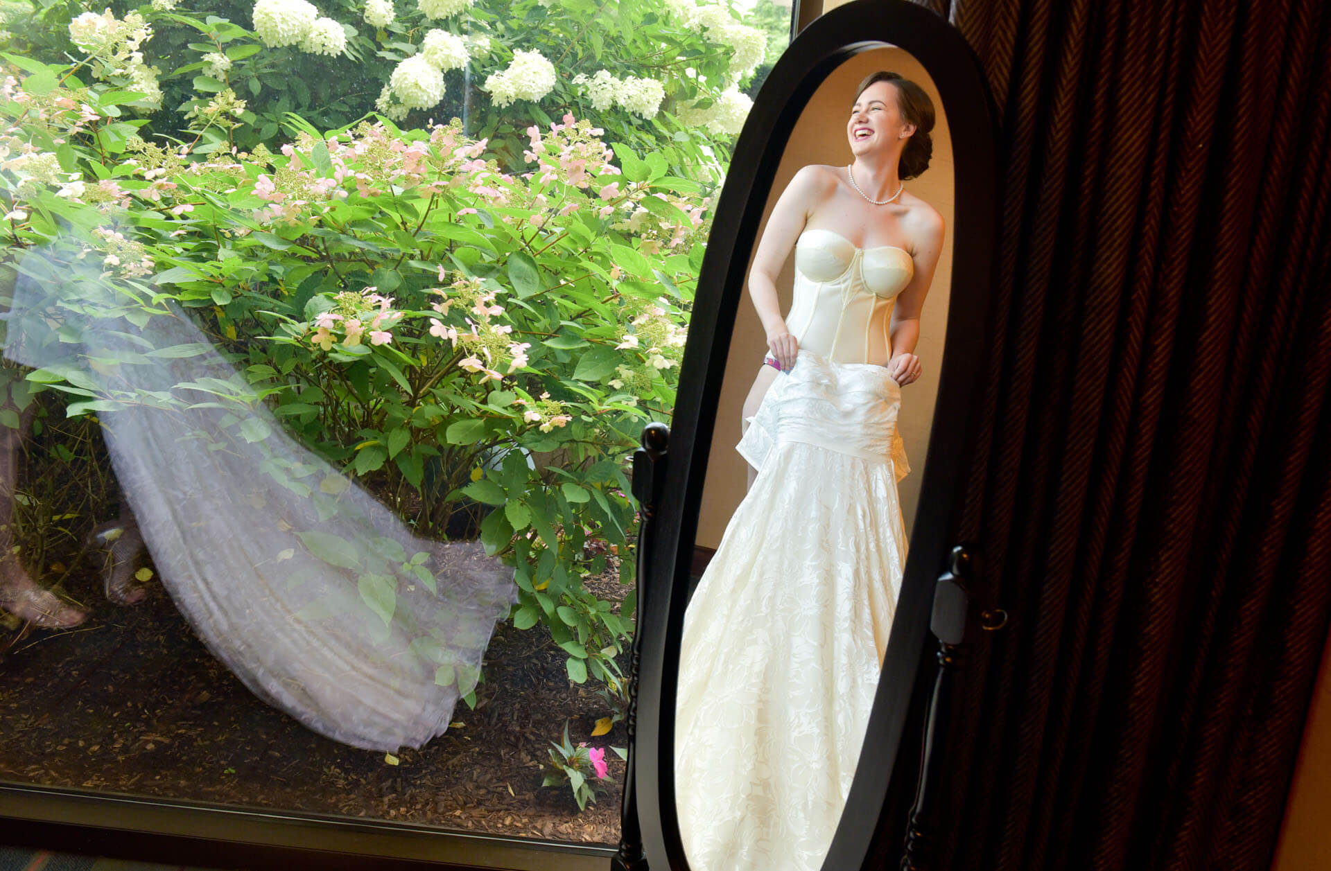 A bride gets dressed in the mirror in Ann Arbor, Michigan.