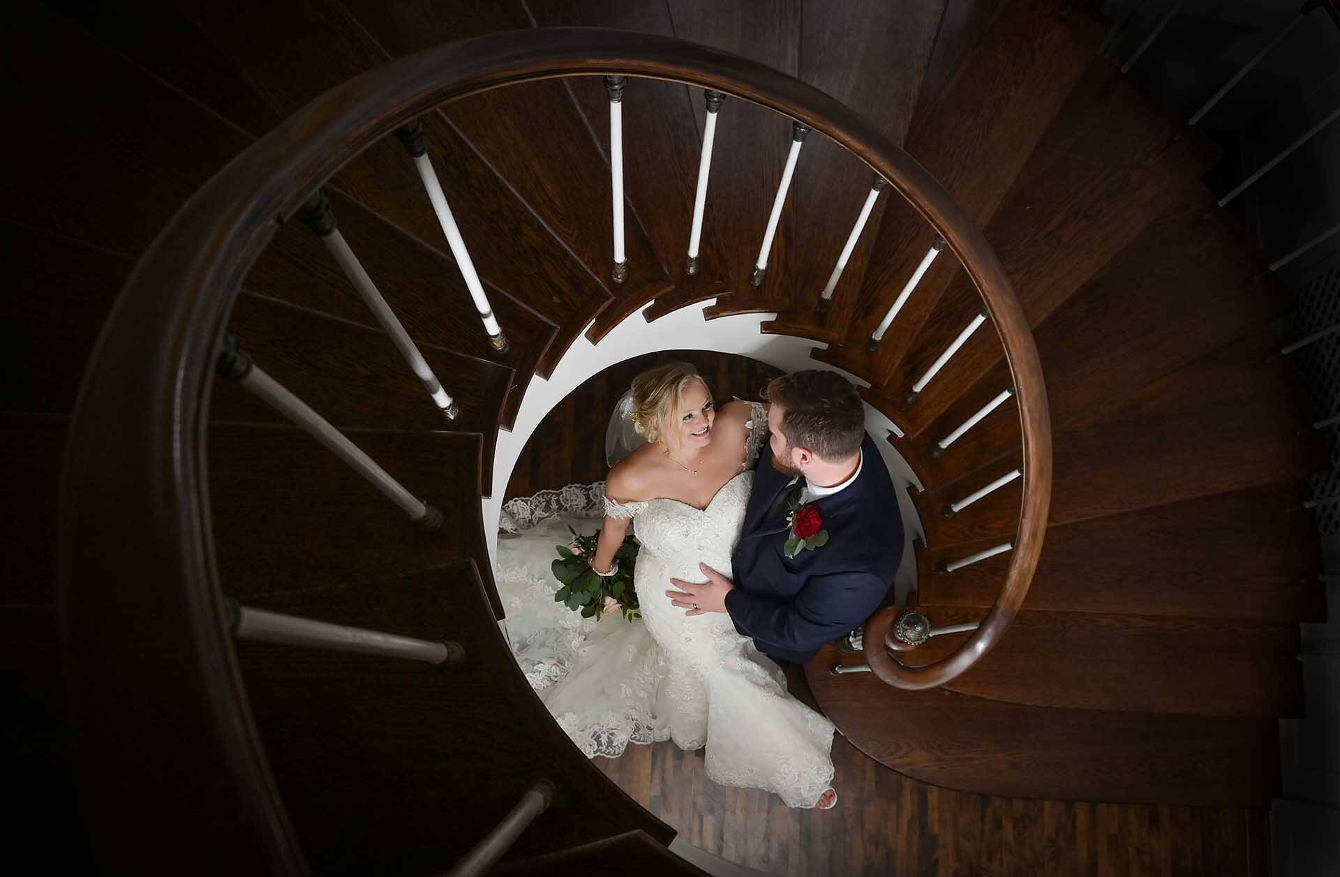timeless wedding photography showing the couple do the his epic portrait of the couple using the Colony Club’s icon spiral stairs in Detroit, Michigan.