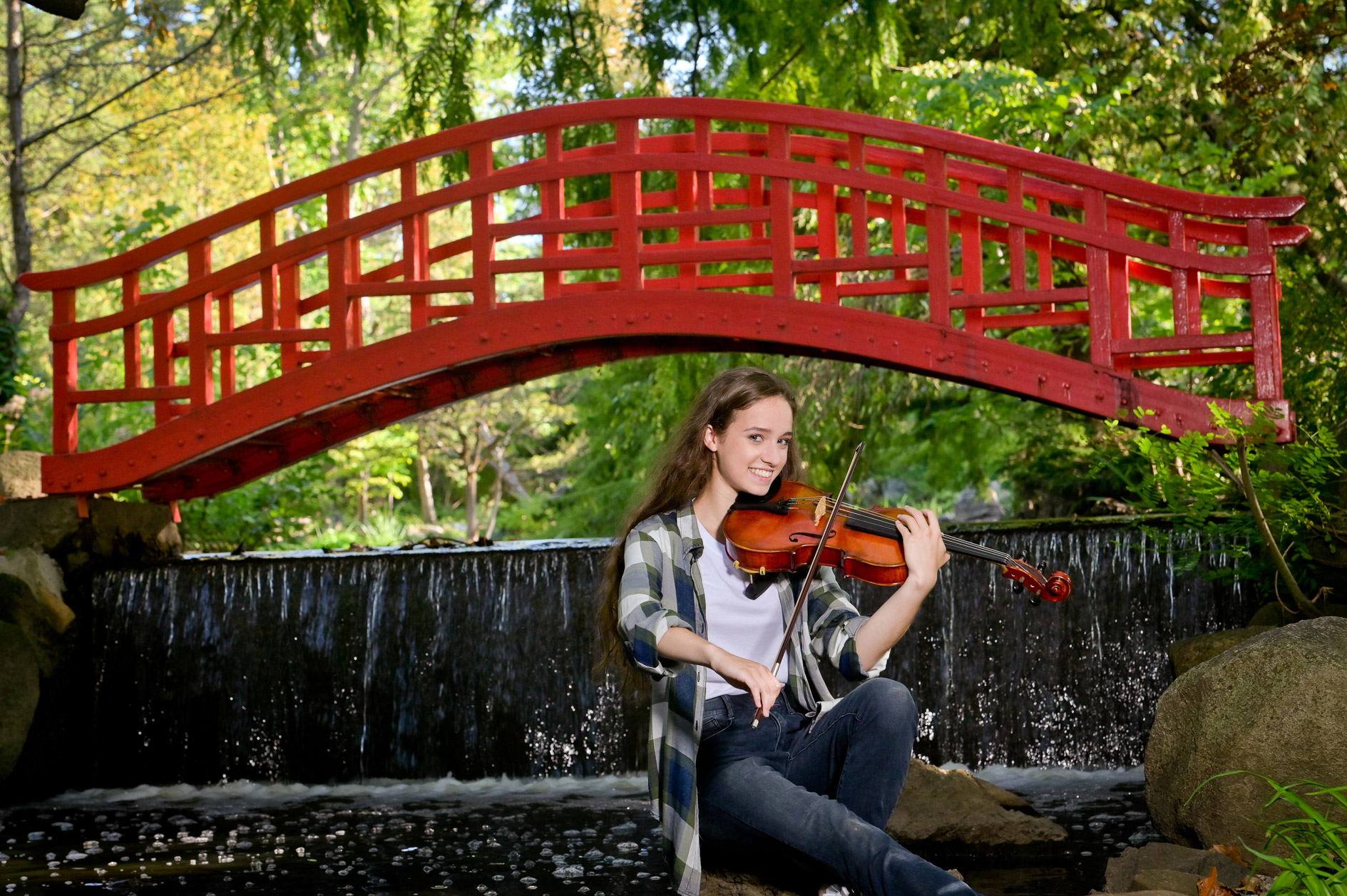 Rachel playing her violin at the Japanese garden with the iconic red bridge at Cranbrook in Oakland County, Michigan.