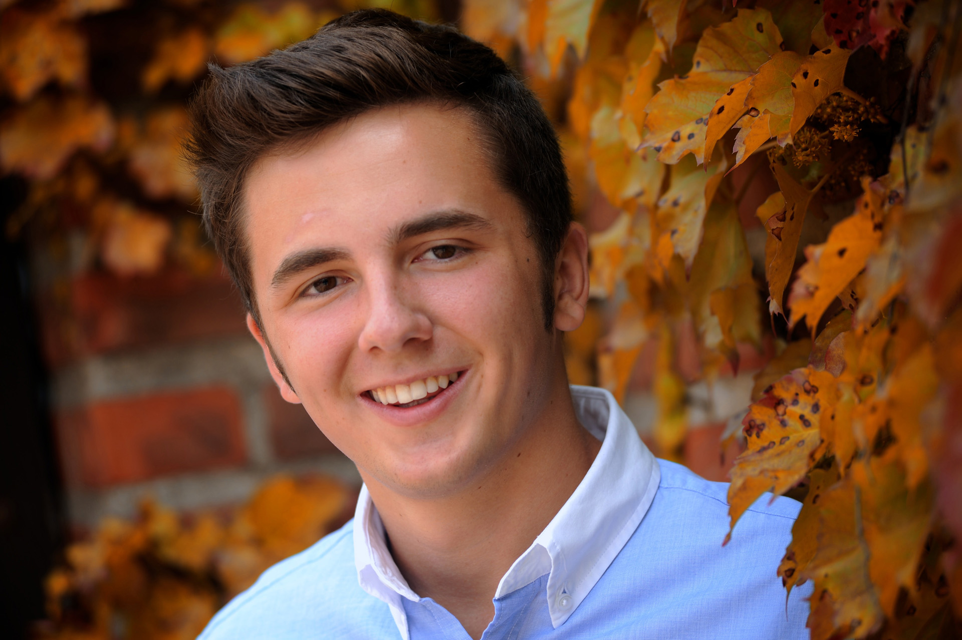 Cranbrook School in Bloomfield, Michigan senior's photo of a Cranbrook senior in with fall colors on campus for his senior photography session at Cranbrook in Bloomfield, Michigan.