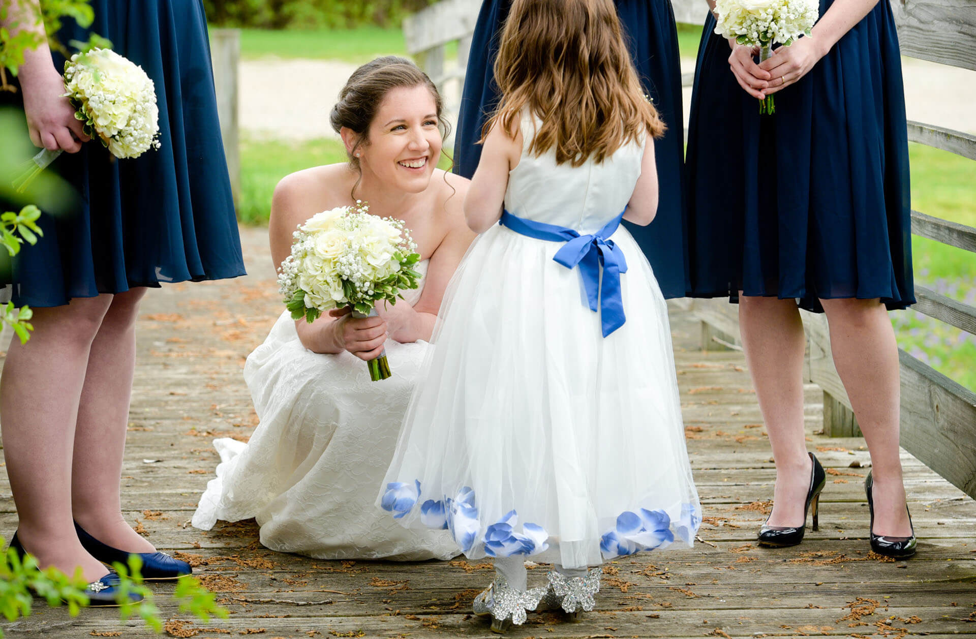 A bride tries to cajole a reticent flower girl at her Stonebridge Golf Club wedding in Ann Arbor, Michigan.