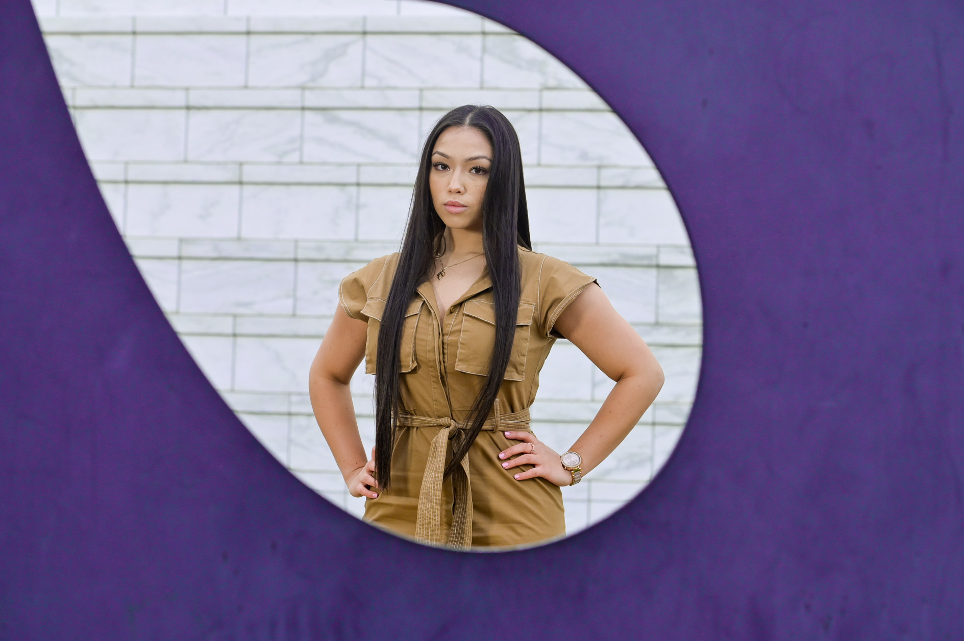 A high school senior girl posing with a sculpture at the Detroit Institute of Arts in Detroit, Michigan.