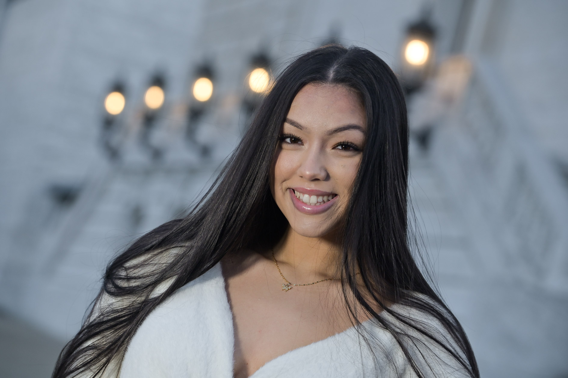 A high school senior girl poses at the Detroit Institute of Arts in Detroit, Michigan at the lights come on.