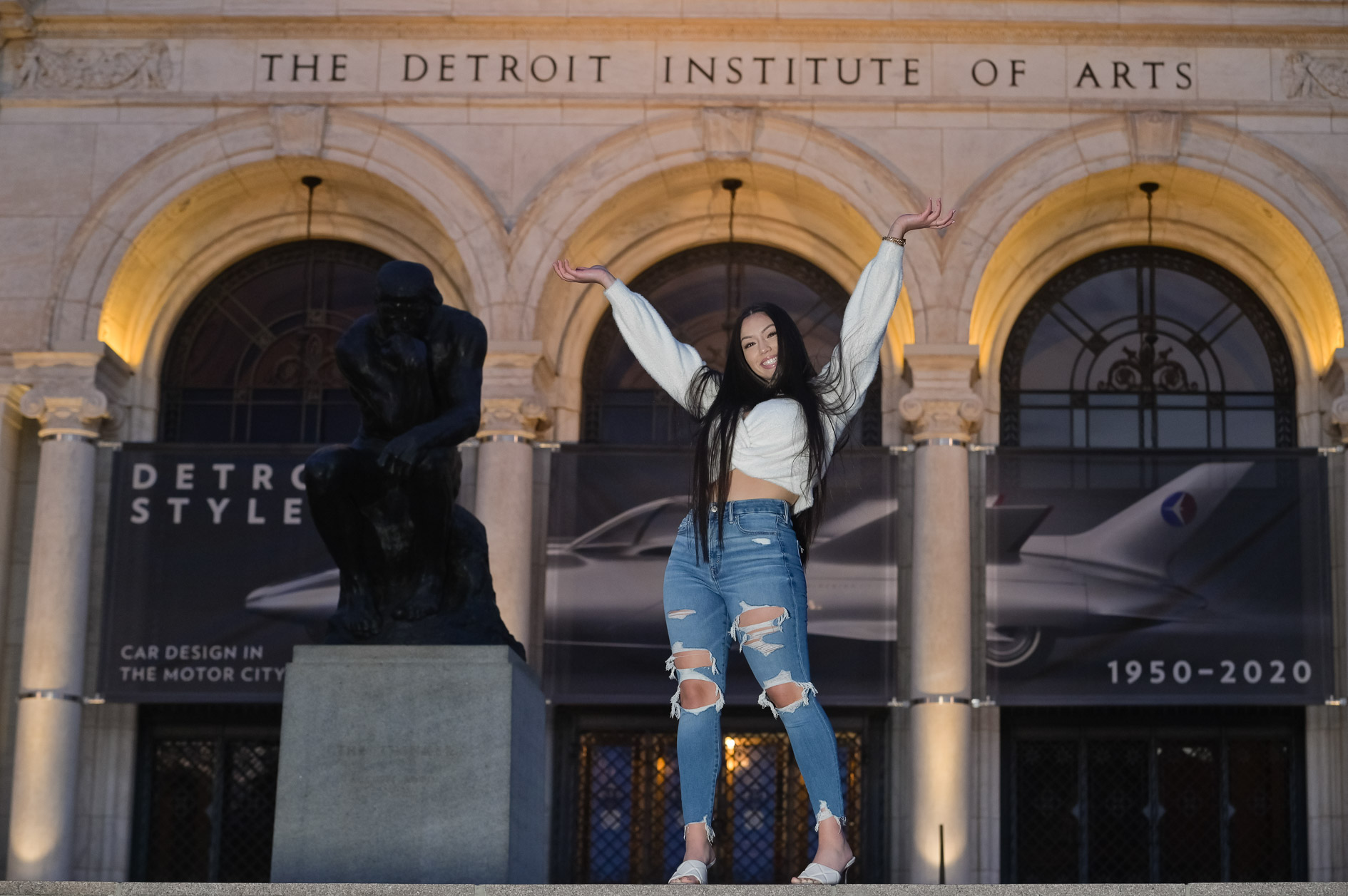 A high school senior girl at the Detroit Institute of Arts in Detroit, Michigan after the sun has set.
