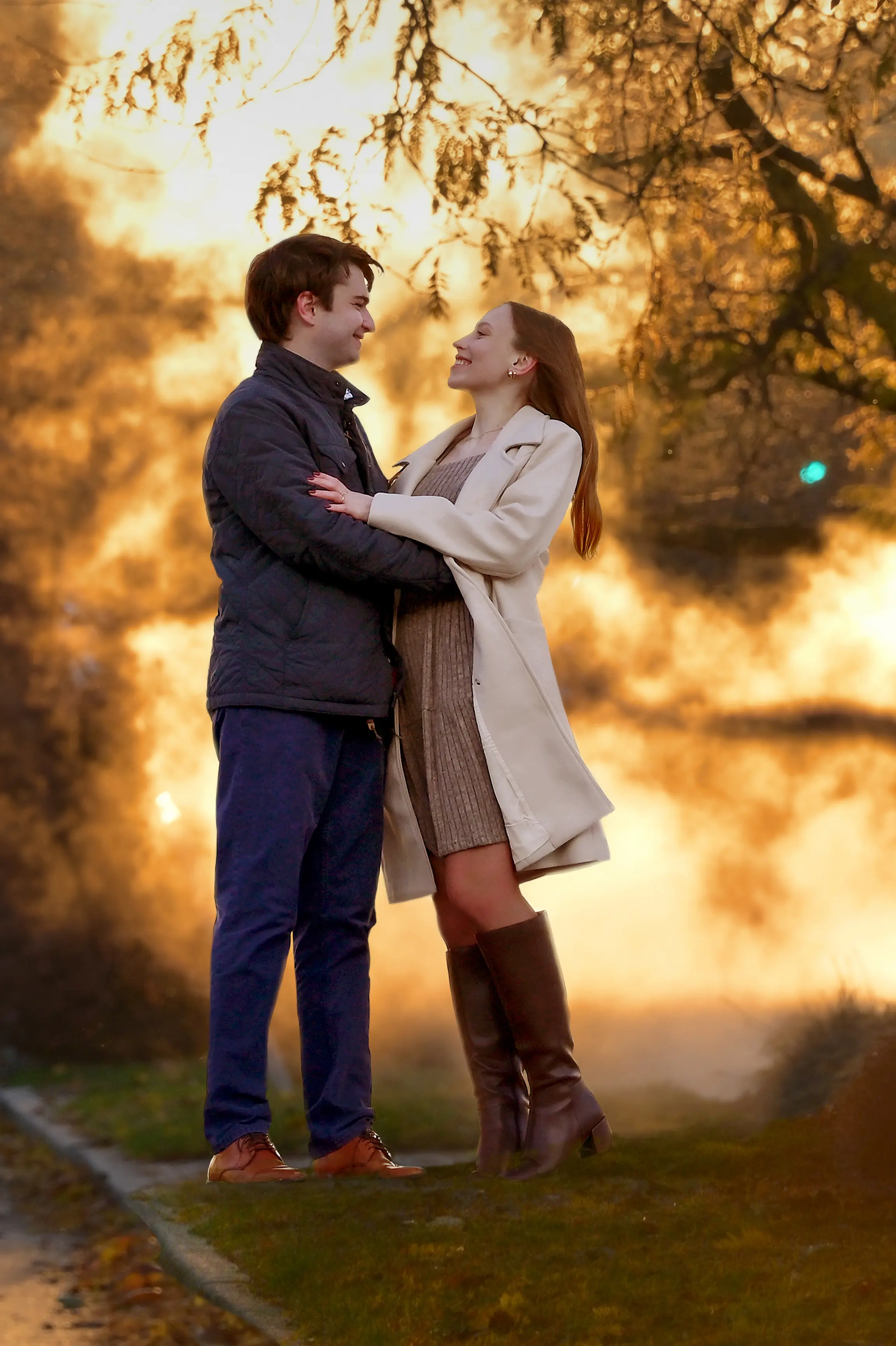 An engagement couple cuddle in the steam during golden hour in Detroit, Michigan during their winter engagement session.