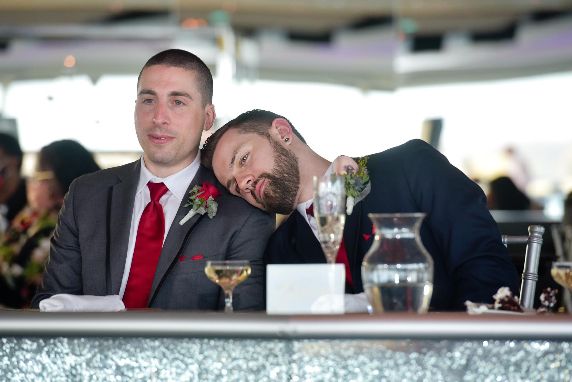 The groom rests his head on the best man's shoulder during speeches at the Roostertail in Detroit, Michigan.