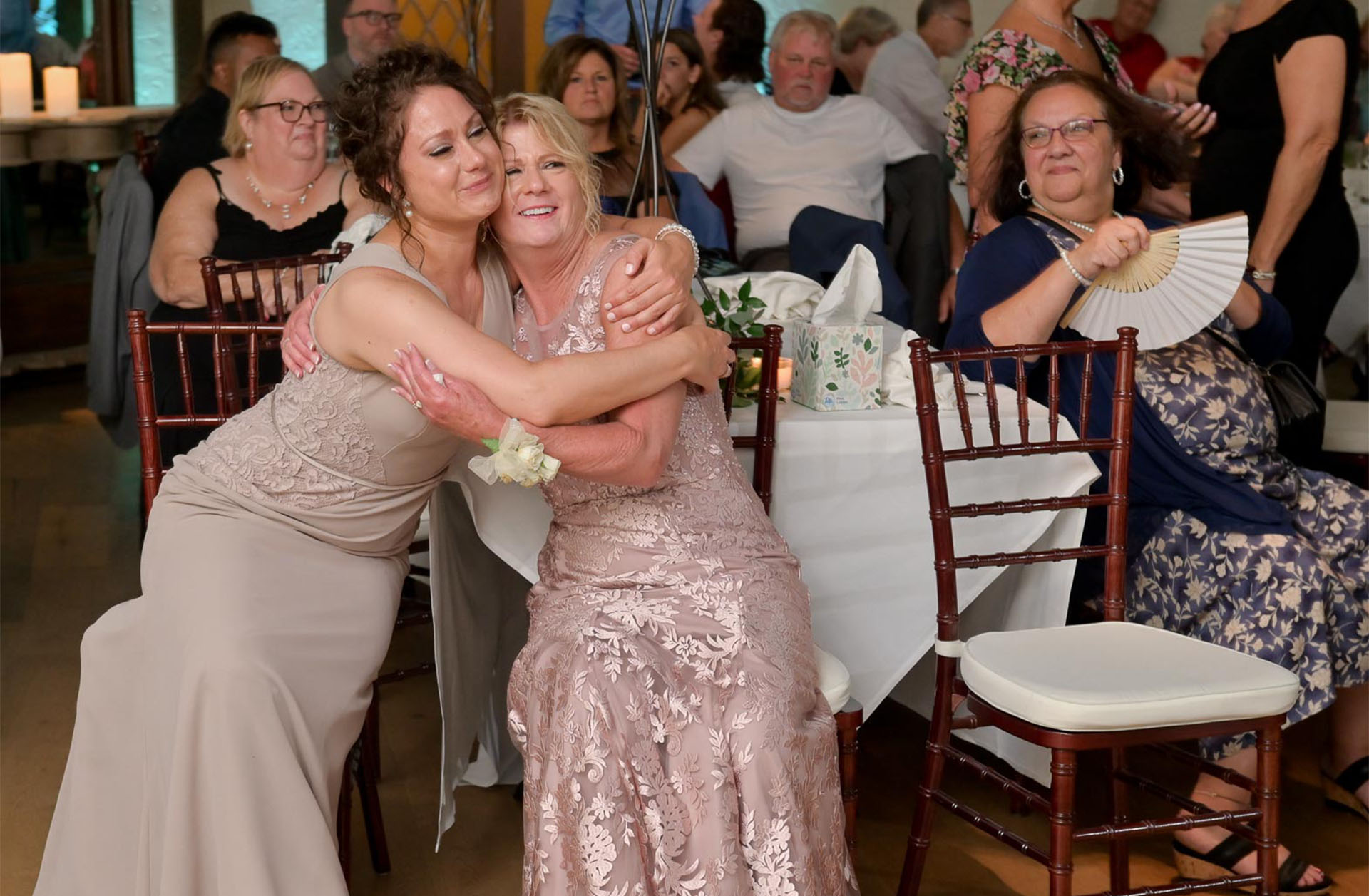 Two moms hug each other during the first dances at their 