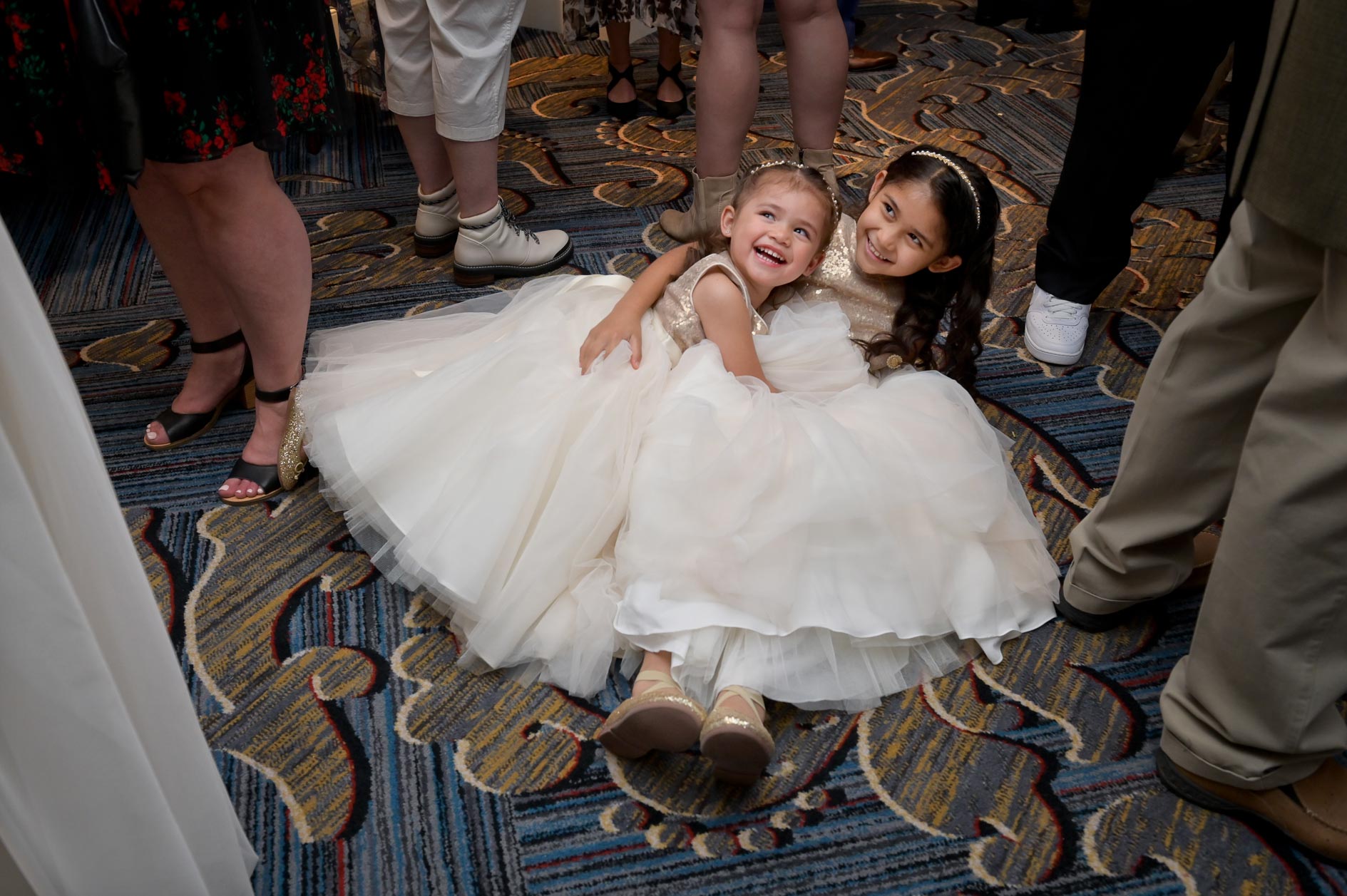 Two flower girls collapse in a pile on the floor during cocktail hour at the Dearborn Inn in Dearborn, Michigan.
