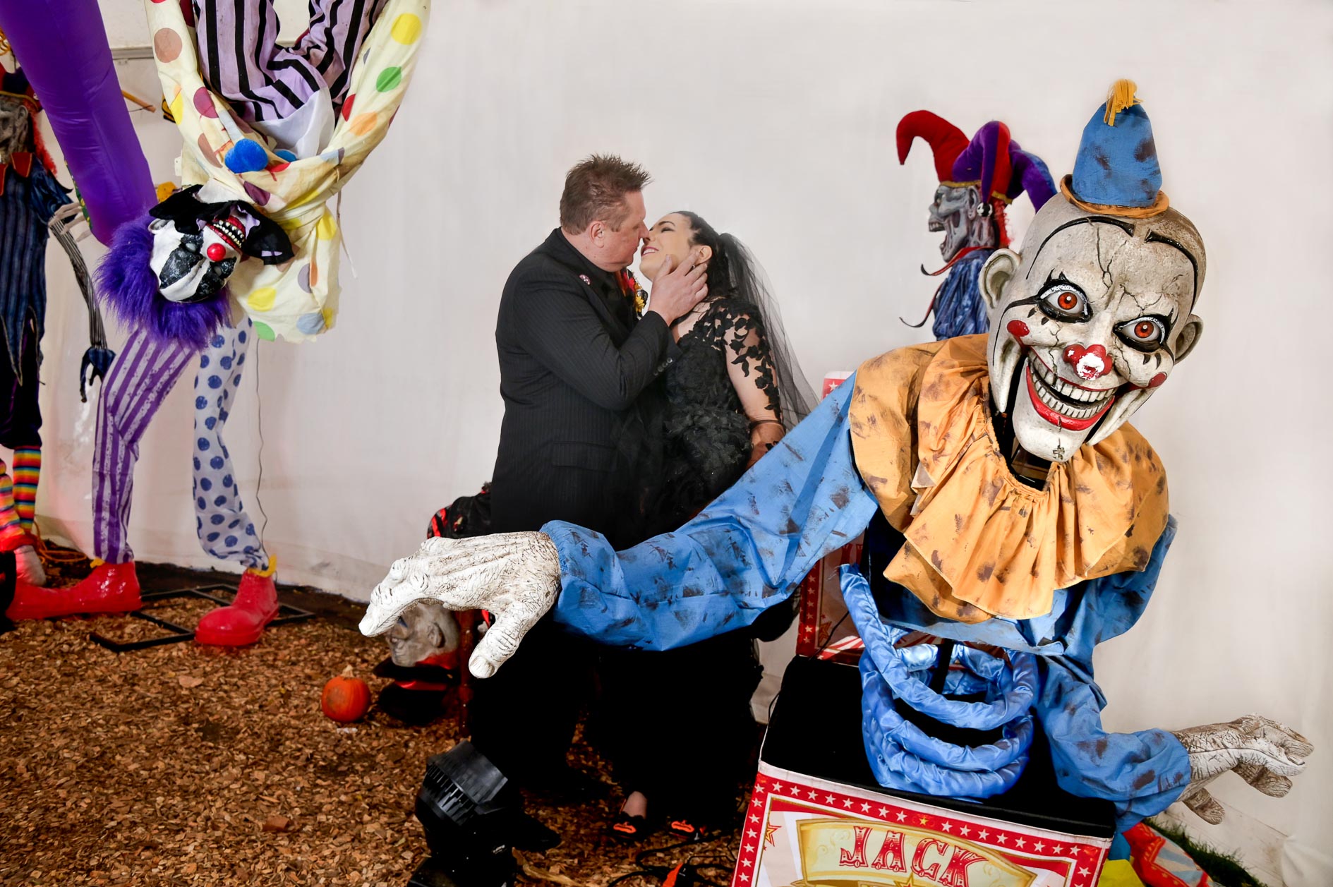 The bride and groom kissing in the clown tent during their Halloween themed wedding at Canterbury Village in Lake Orion, Michigan.