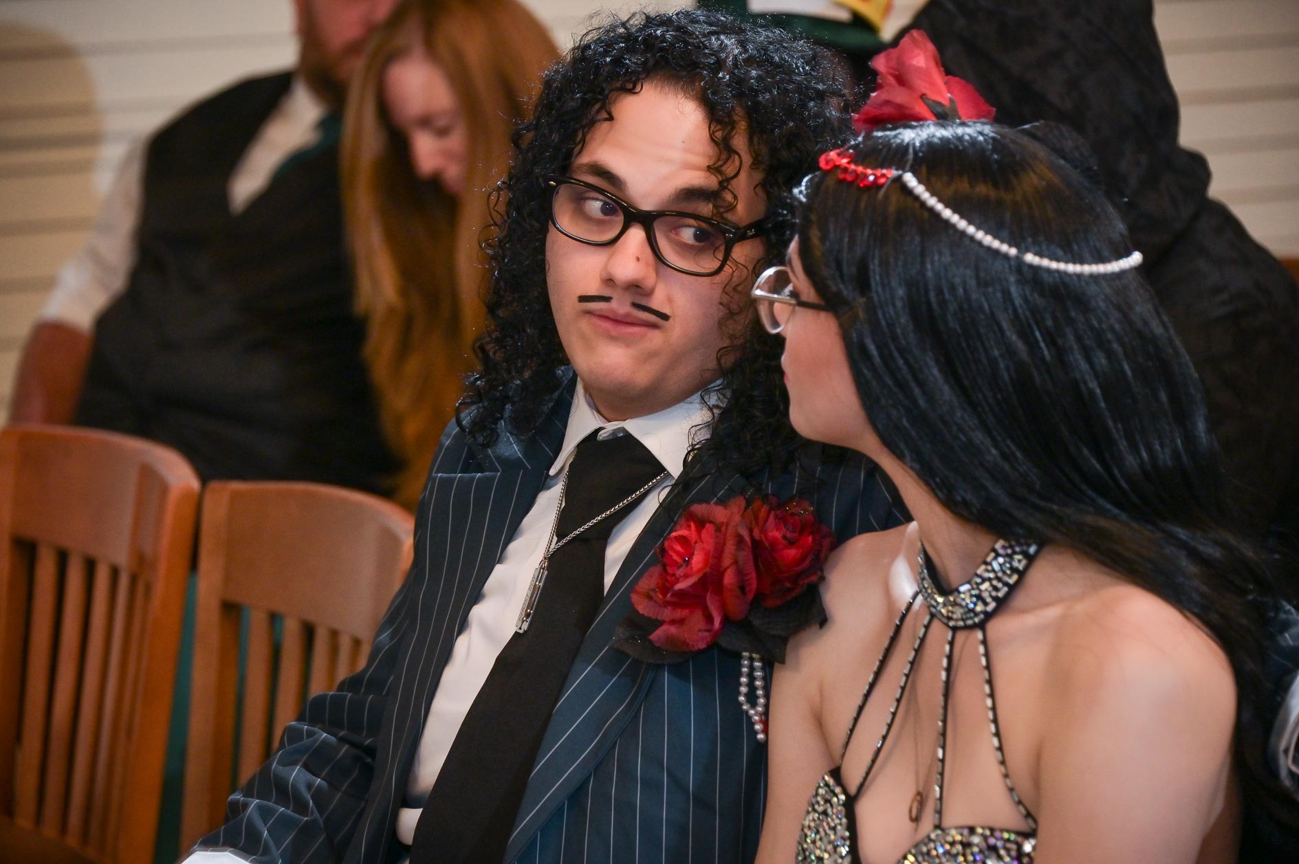 Wedding guests chatting at a Halloween themed wedding at the chapel in Canterbury Village in Lake Orion.