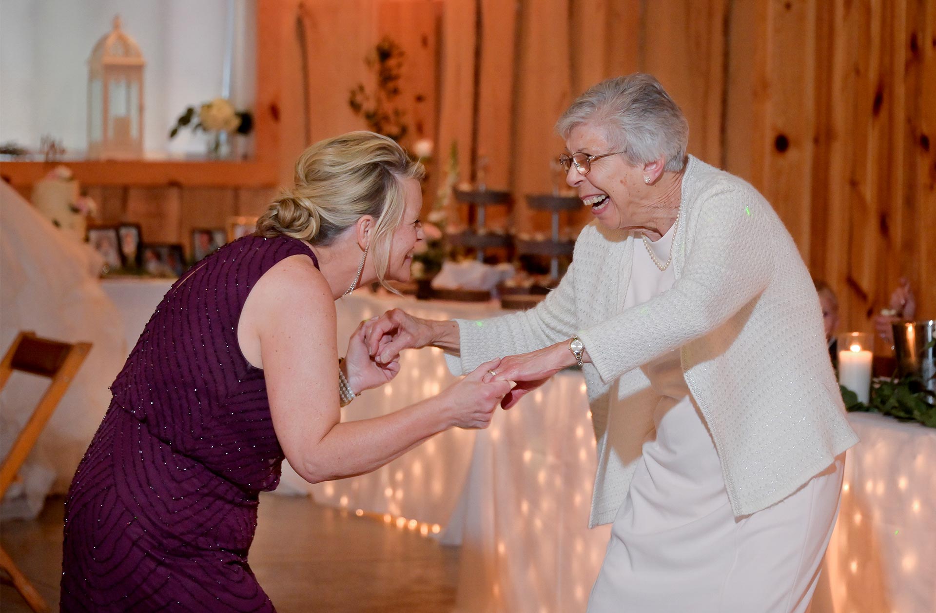 The mother of the groom dances with an older guest at a wedding in the Christmas Tree farm in Lainsburgh, Michigan.