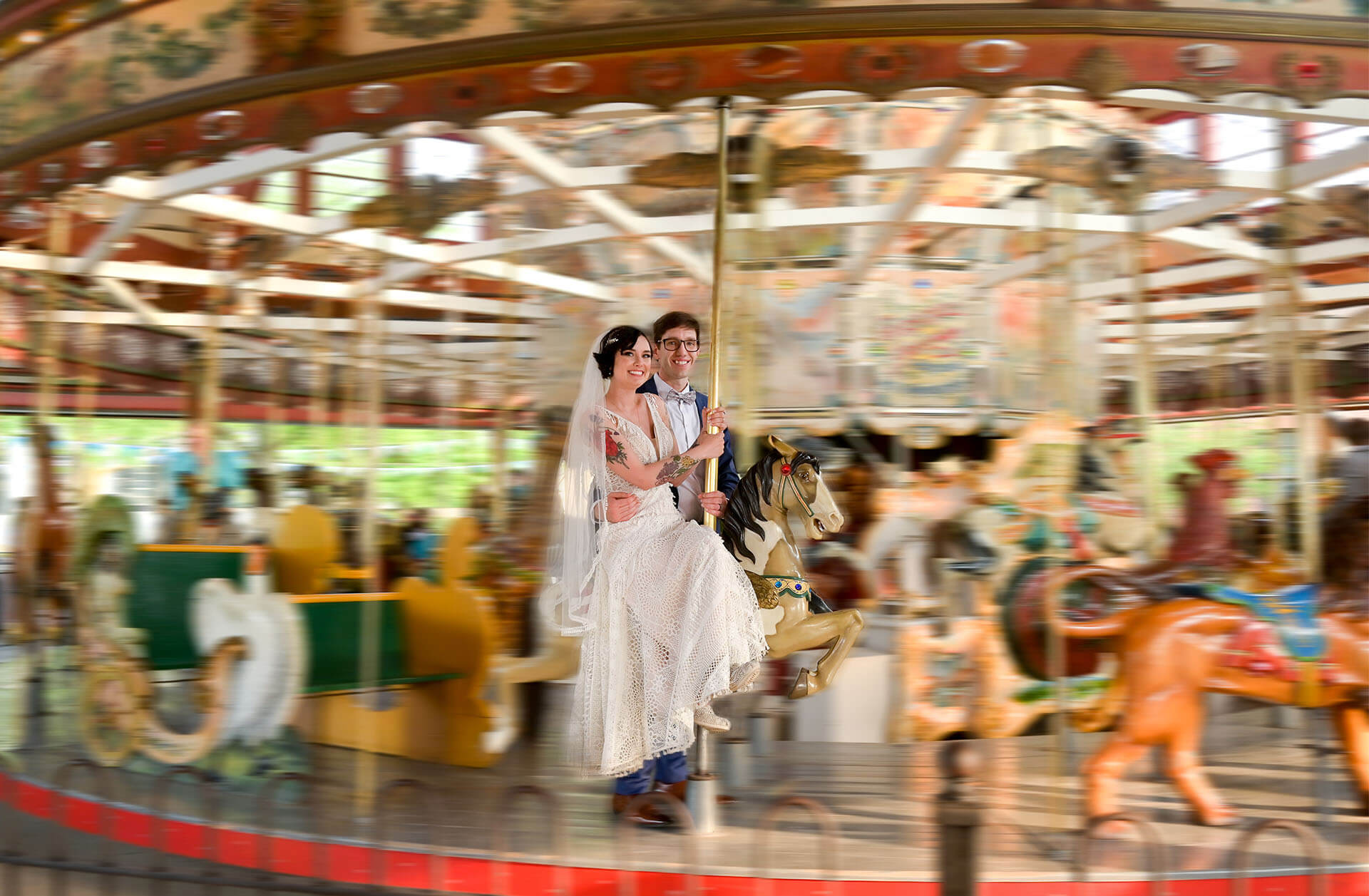 A couple pose on carousel at Greenfield Village in Dearborn, Michigan after their wedding.