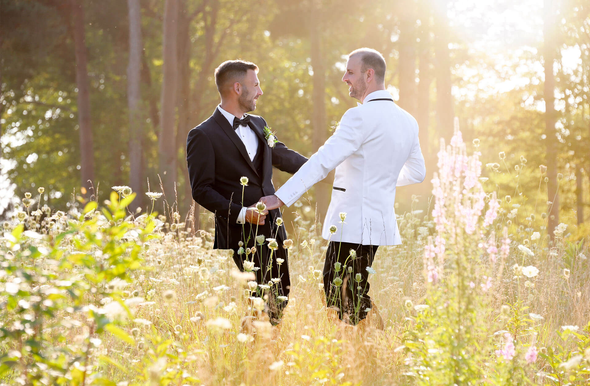 A cute gay couple dancing in the fields of Solitude Links in Port Huron, Michigan for a timeless portrait.