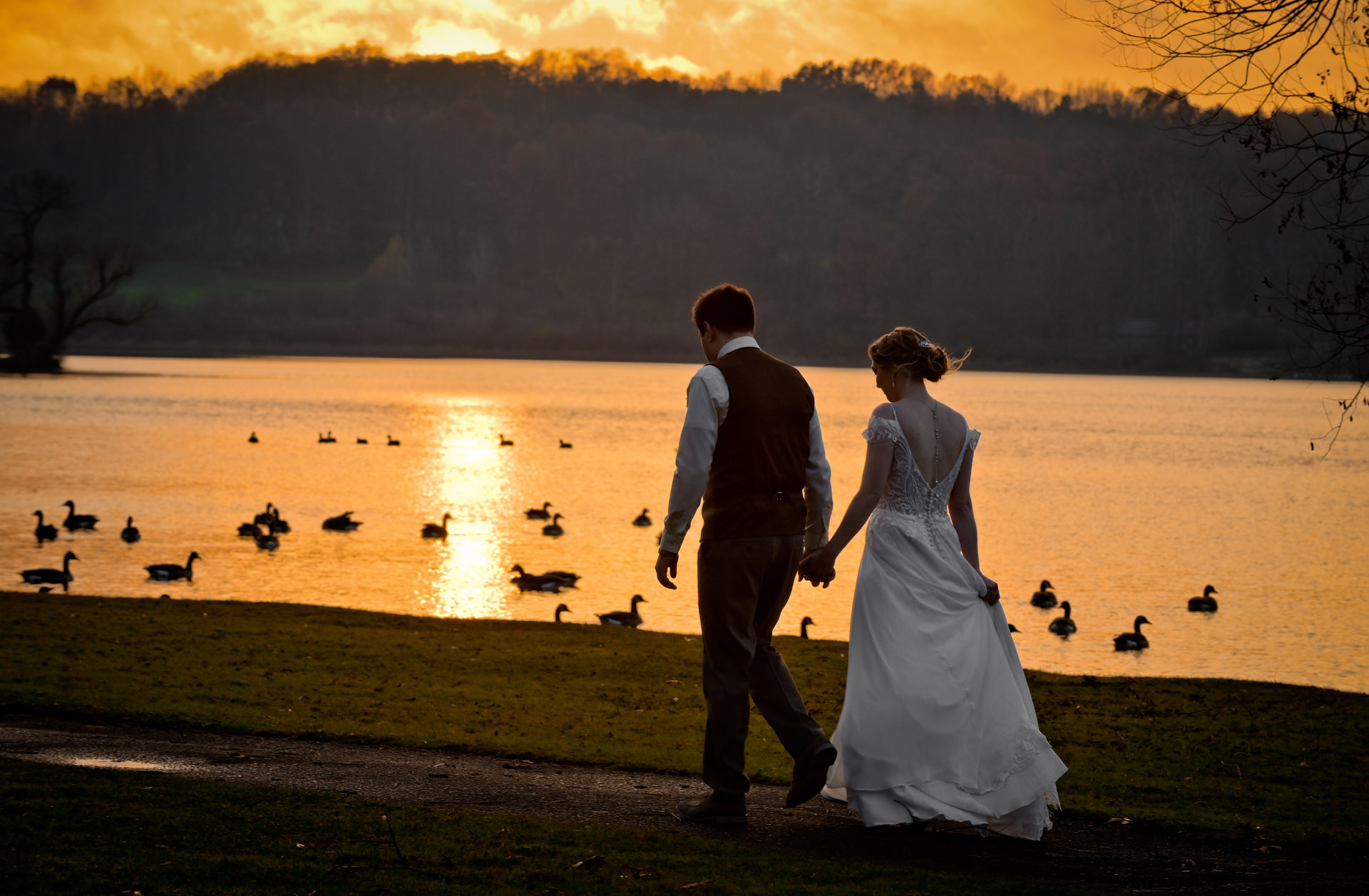 A couple walk during sunset after their wedding at Waldenwoods Resort in Howell, Michigan.