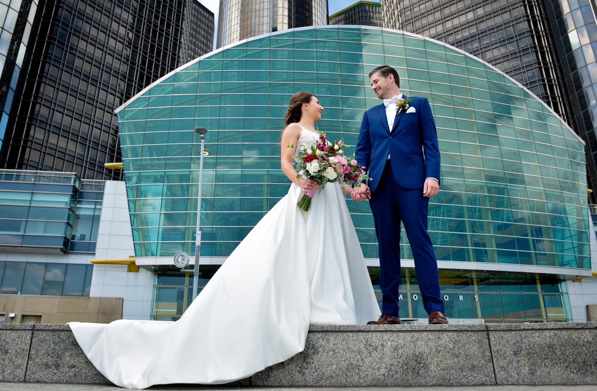 A couple pose in front of the Renaissance Center downtown Detroit, Michigan.