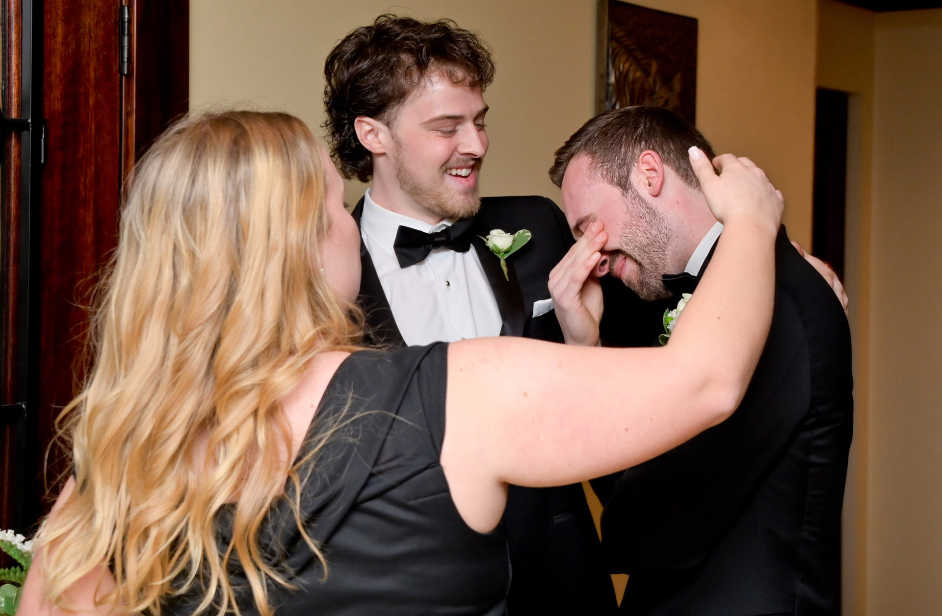 The best man and the maid of honor comfort the groom as he cries after his wedding ceremony at the Iroquois Club in Bloomfield Hills, Michigan.
