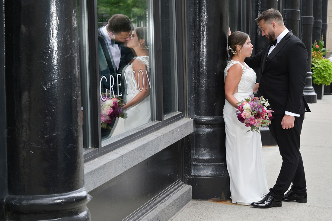Look closely at the bride and groom in the window and on the sidewalk during their wedding ceremony at the Gem Theatre in Detroit, Michigan.