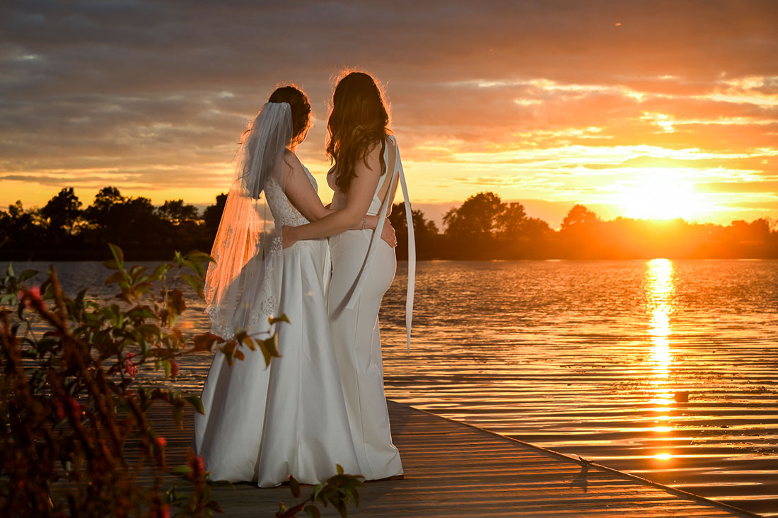 The LGBTQ couple at sunset on the dock at their AirBnb in Grass Lake, Michigan.