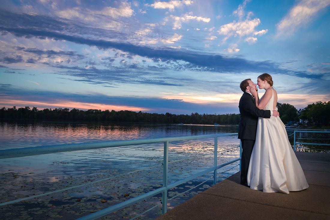 The couple hanging out on the deck at sunset during their wedding at the Lakeview Banquet and Event Center in Laingsburg, Michigan..