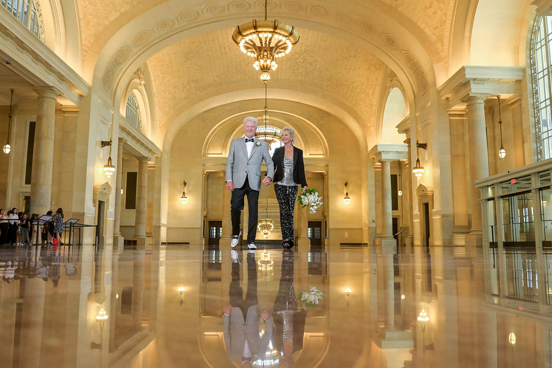 The bride and groom strolling in the atrium at the newly renovated Michigan Central (the old Detroit train station) in Detroit, Michigan after their intimate, secret wedding ceremony.