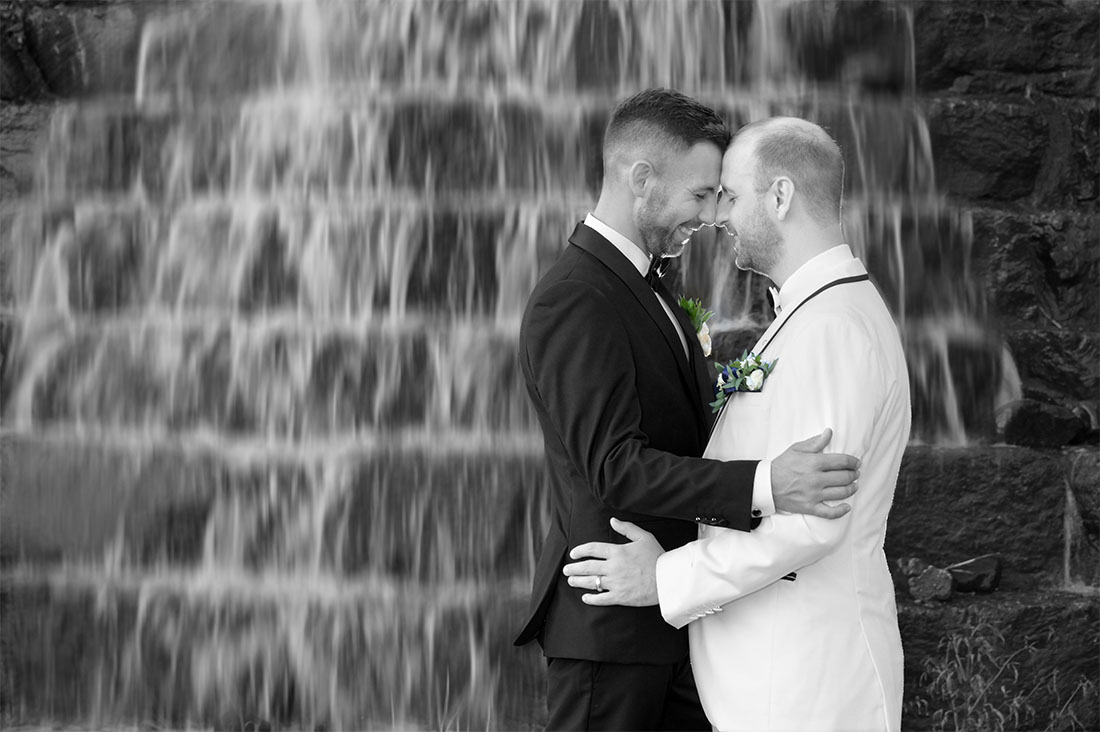 The LGBTQ couple at sunset with a waterfall flowing at the Solitude Links Golf and Banquet Center in Kimball, Michigan.