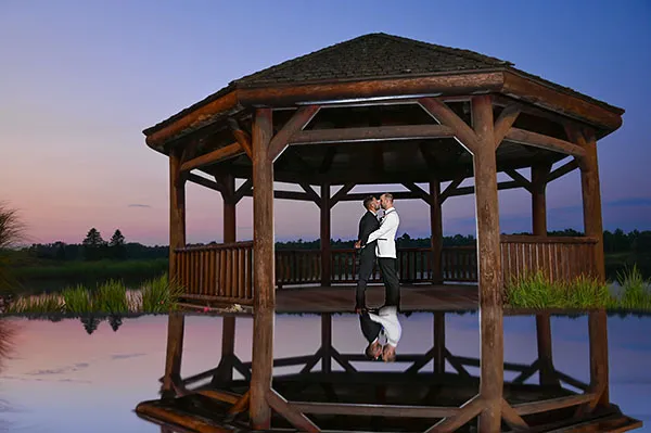 Two grooms nuzzling in the pines of Solitude Links in Kimball, Michigan before their LGBTQ wedding.