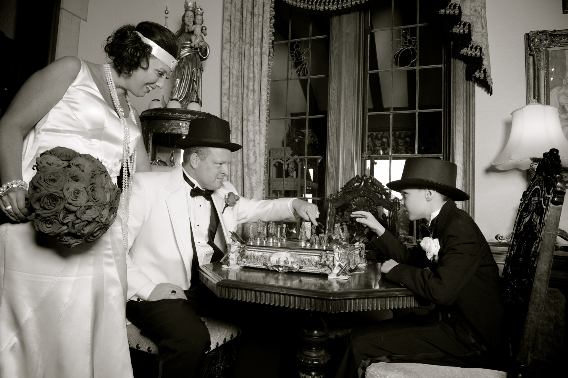 Michigan wedding at Birmingham, featured a trip to a turn of the century mansion nearby where the bride and groom and their son pose for an old fashioned portrait playing chess at their 1920's themed wedding int Birmingham, Michigan's Big Rock's wedding venue The Reserve.