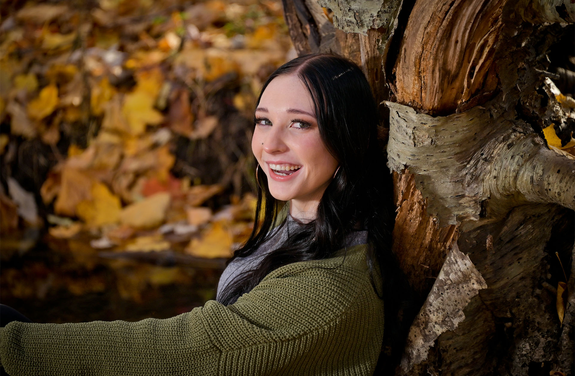 Using natural surroundings like trees for fall senior photos near Troy, MI,