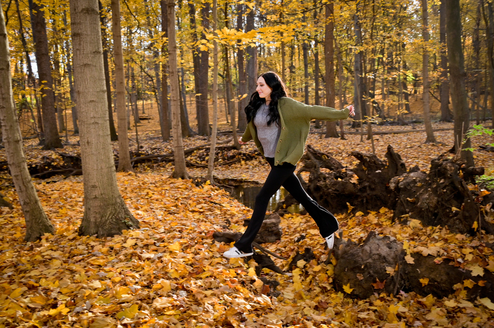 Troy High school senior jumping in yellow leaves near Troy, Mich.
