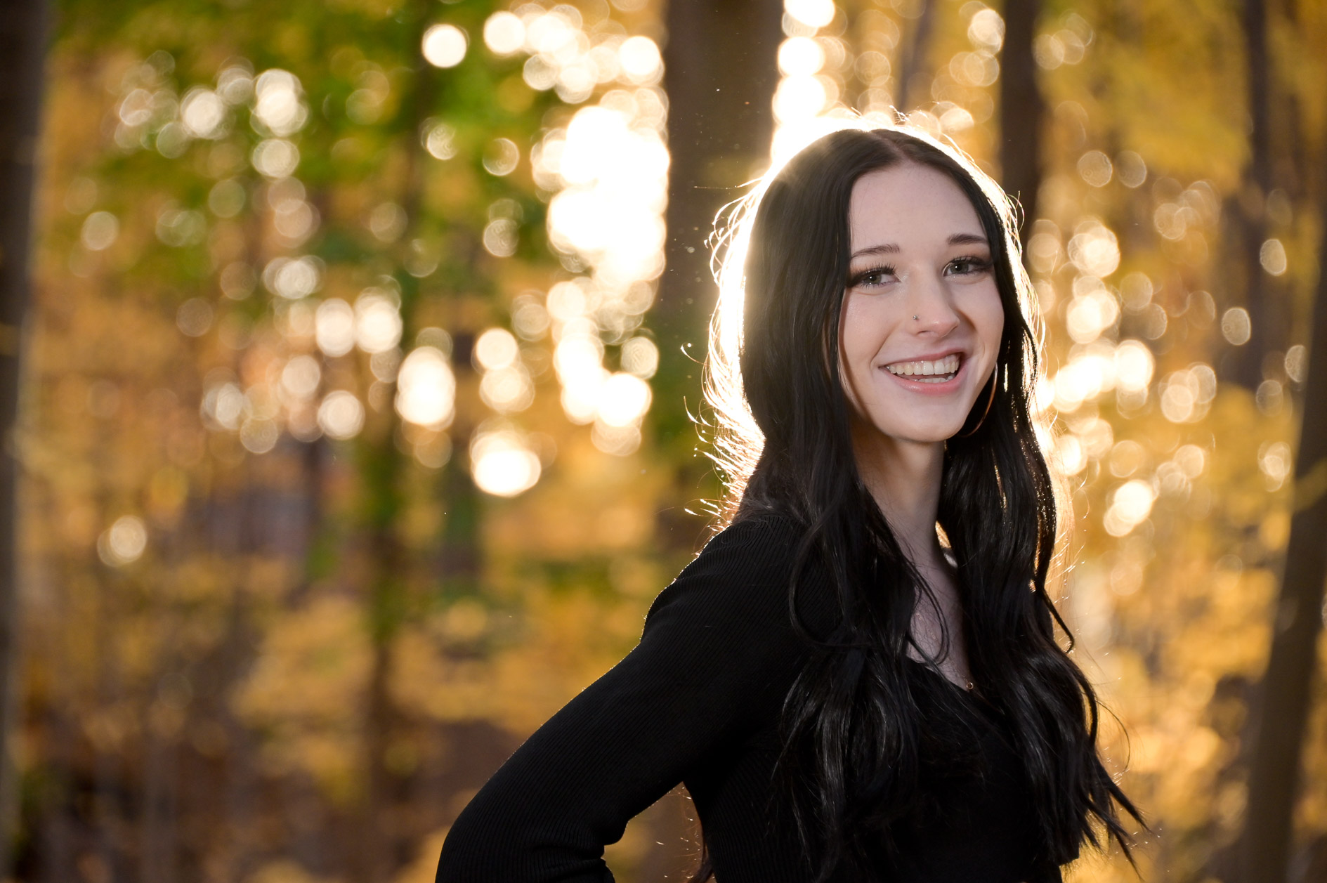 Senior girl with sun flaring in the evening in fall.
