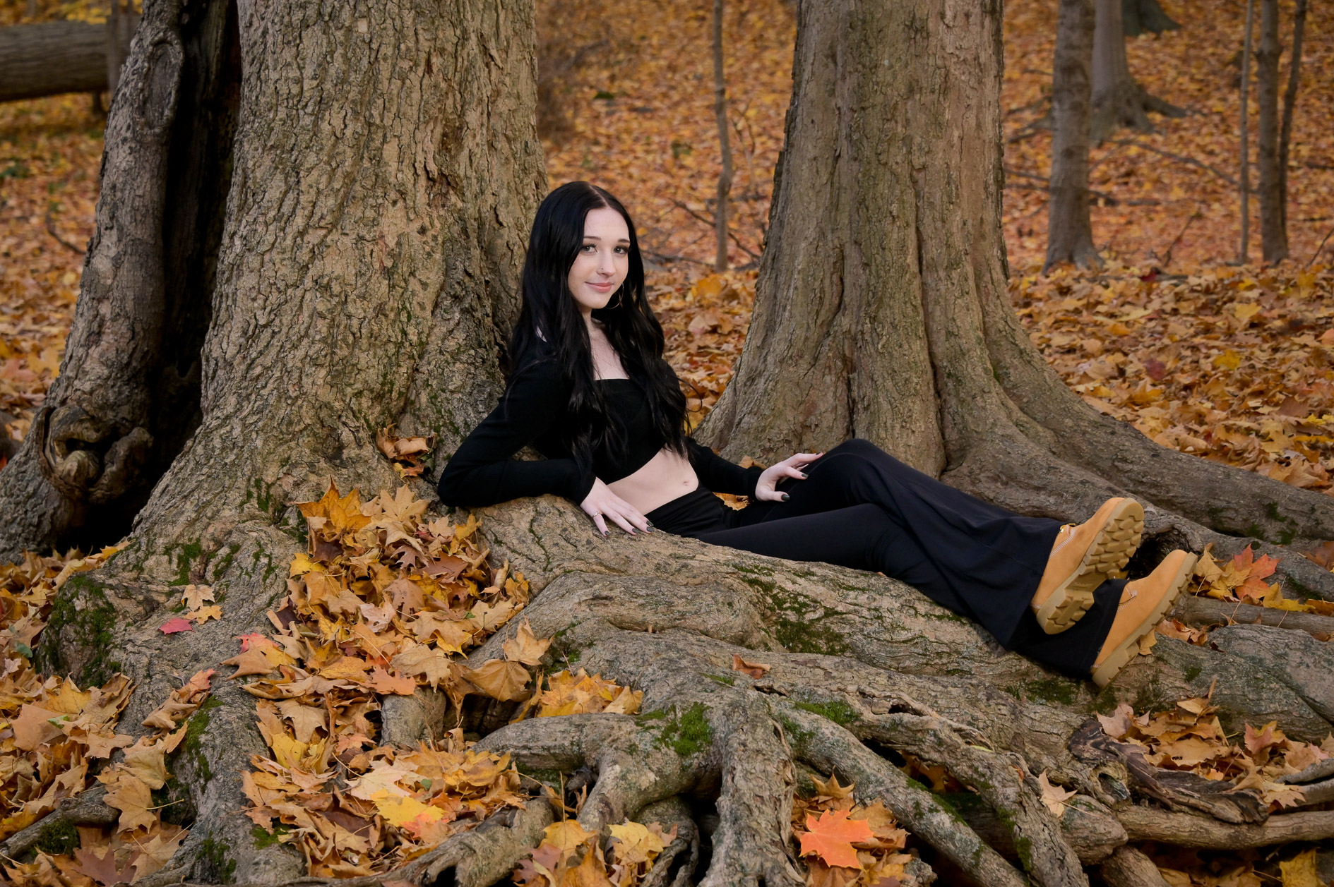 Troy senior makes herself comfortable in the roots of trees in the autumn fall colors near Troy, MI. 