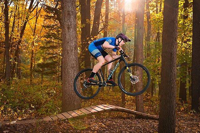 A Troy High senior takes his mountain bike on an obstacle course in a park near Troy, Michigan for his senior photo.