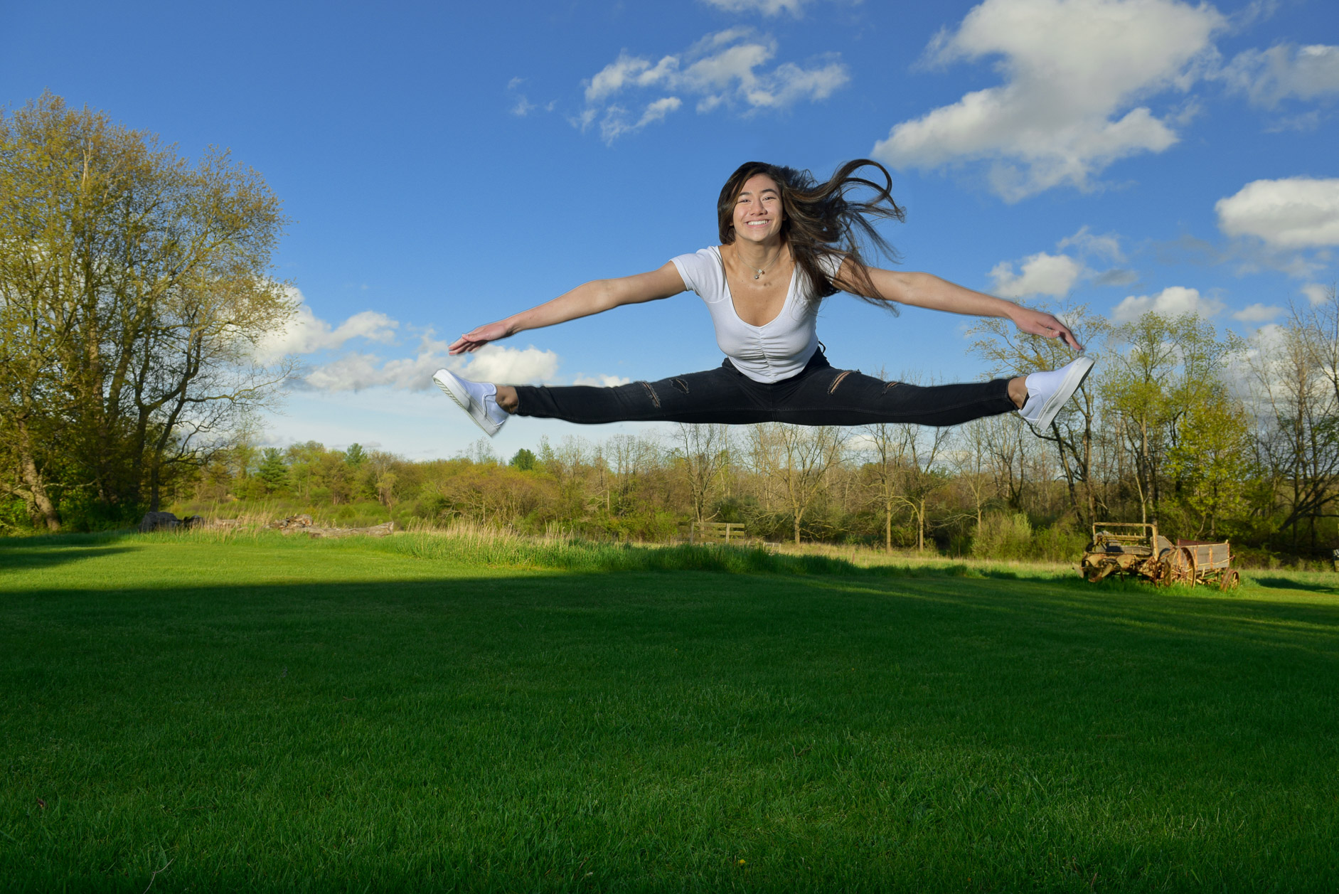 A high school senior shows off her best slits jump for senior photos in Troy Michigan.