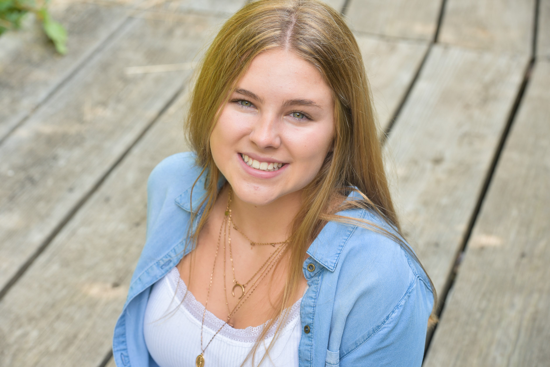 A high school senior girl sits near a river in Troy, Michigan.