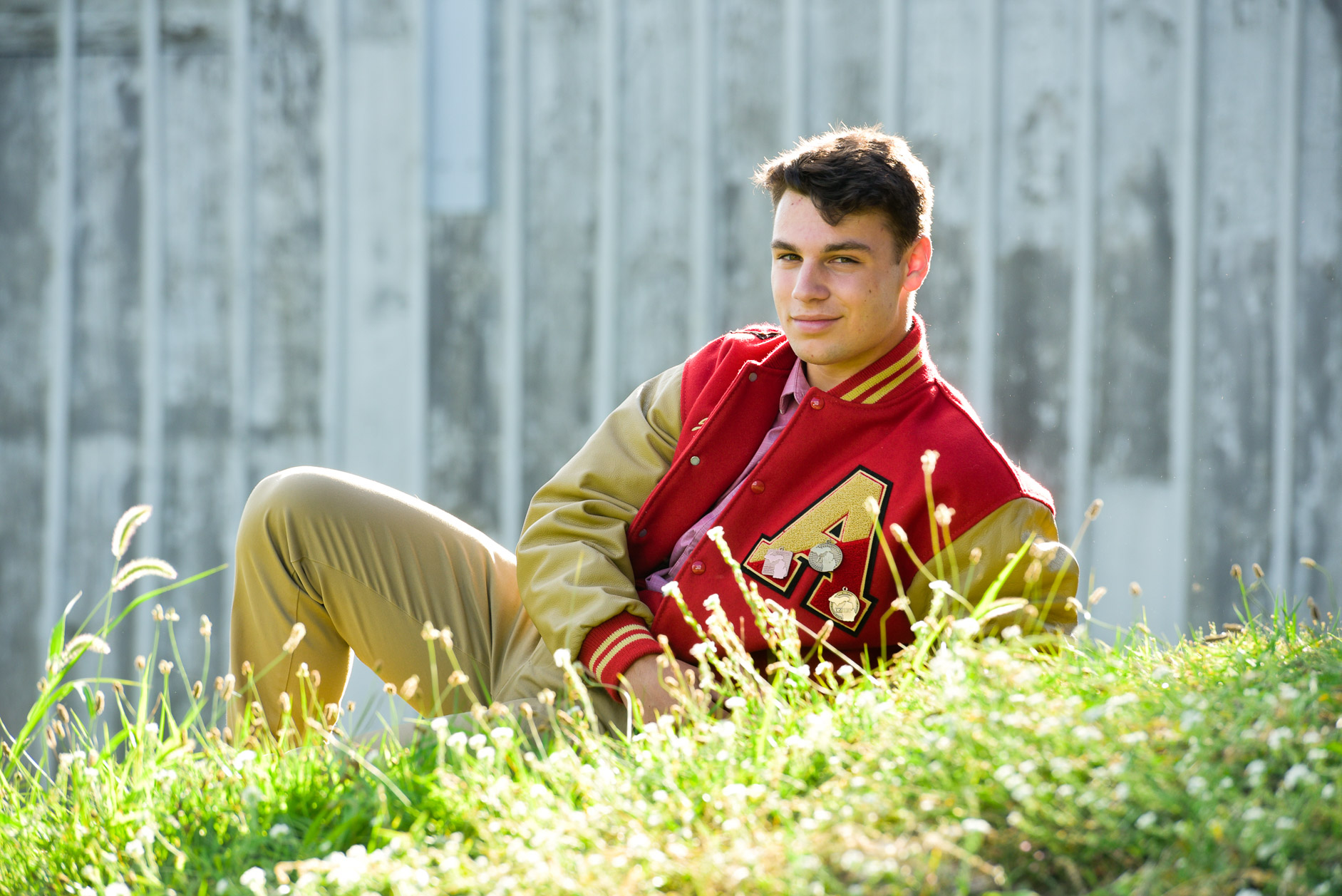 Troy Athens senior photographer's photo of the high school senior with his letter jacket taken in Troy, Michigan.