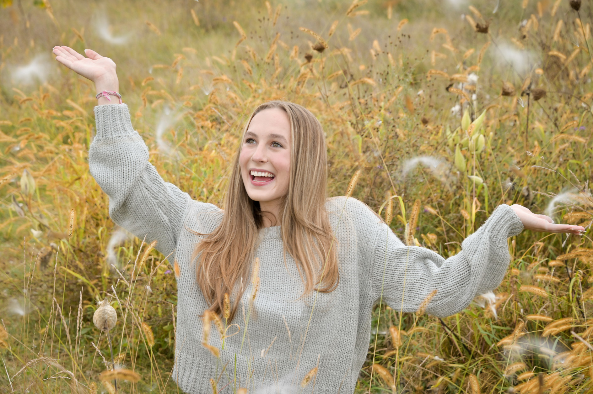 Troy High senior photographer's photo playing with the giant seeds in the a field in Troy Michigan.