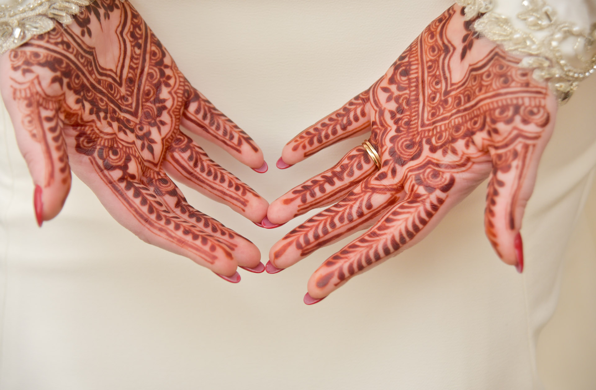 The bride's henna's hands sit in her lap during her winter wedding in Plymouth, Michigan.