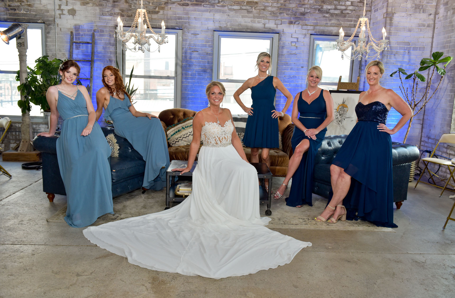 The bride and her bridesmaids rest on furniture provided at the venue in Detroit before the start of their wedding reception.