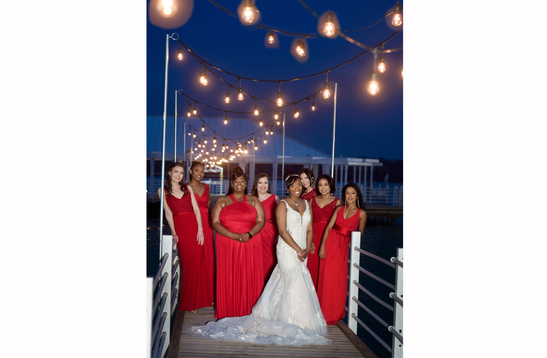 The bridesmaids pose on the docks of the Roostertail in Detroit, Michigan as night falls in winter.