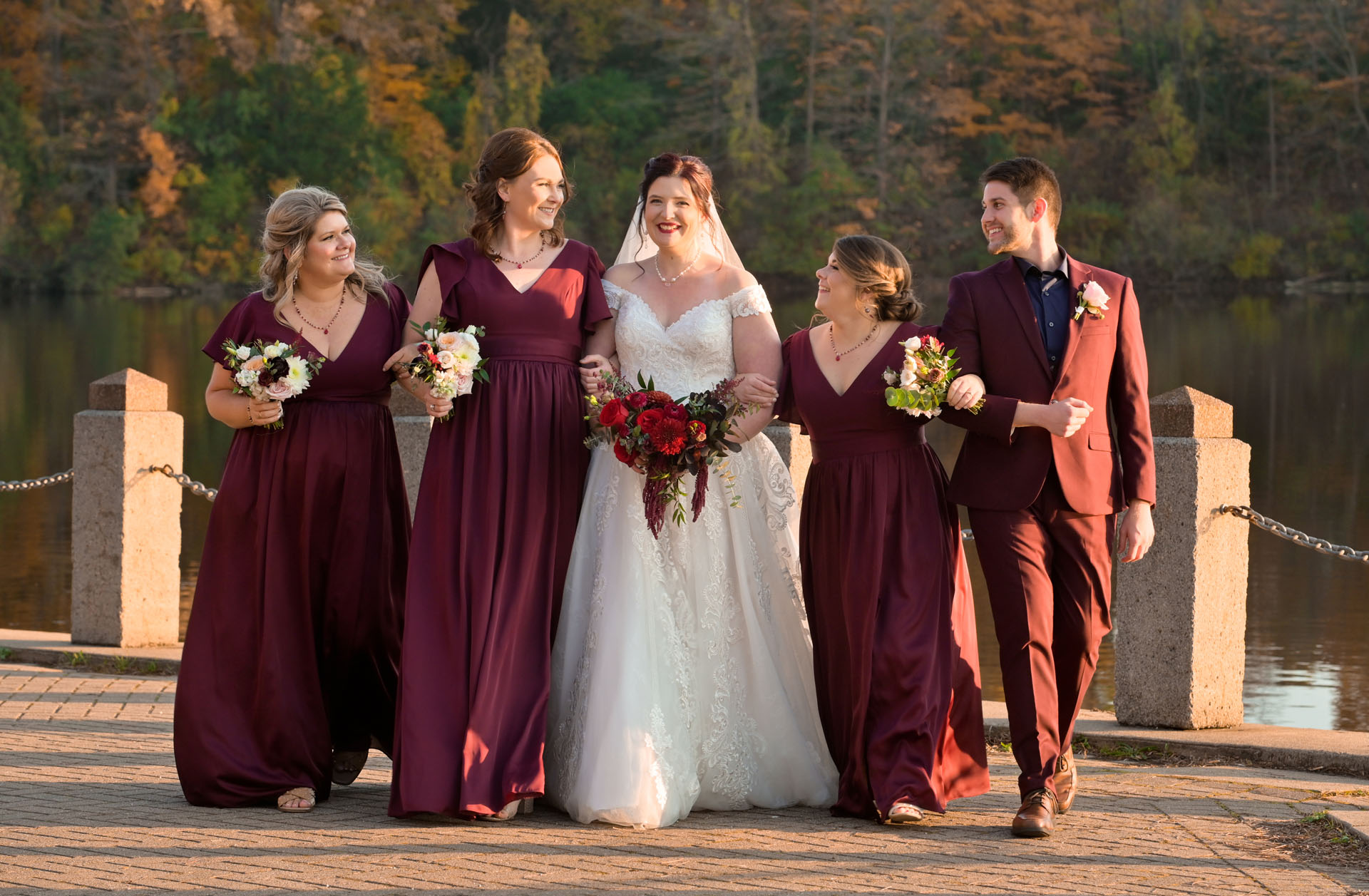 The bride's side of the bridal party stroll on the docks of a park in Livonia, Michigan during 